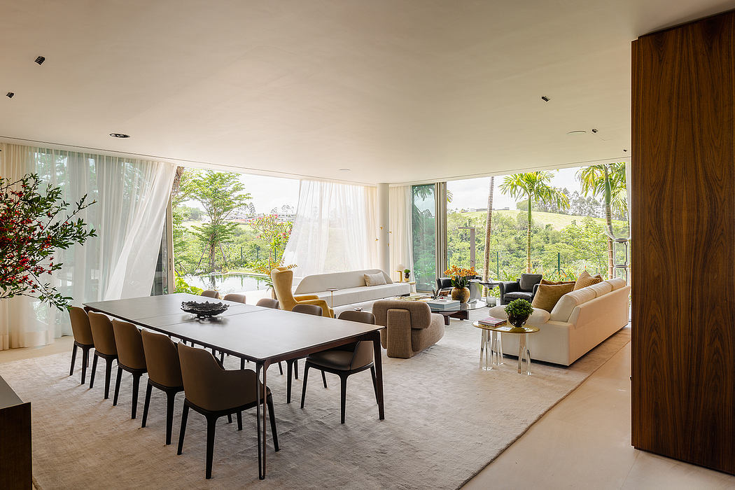 Spacious, open-concept living area with large windows, plush seating, and modern dining set.