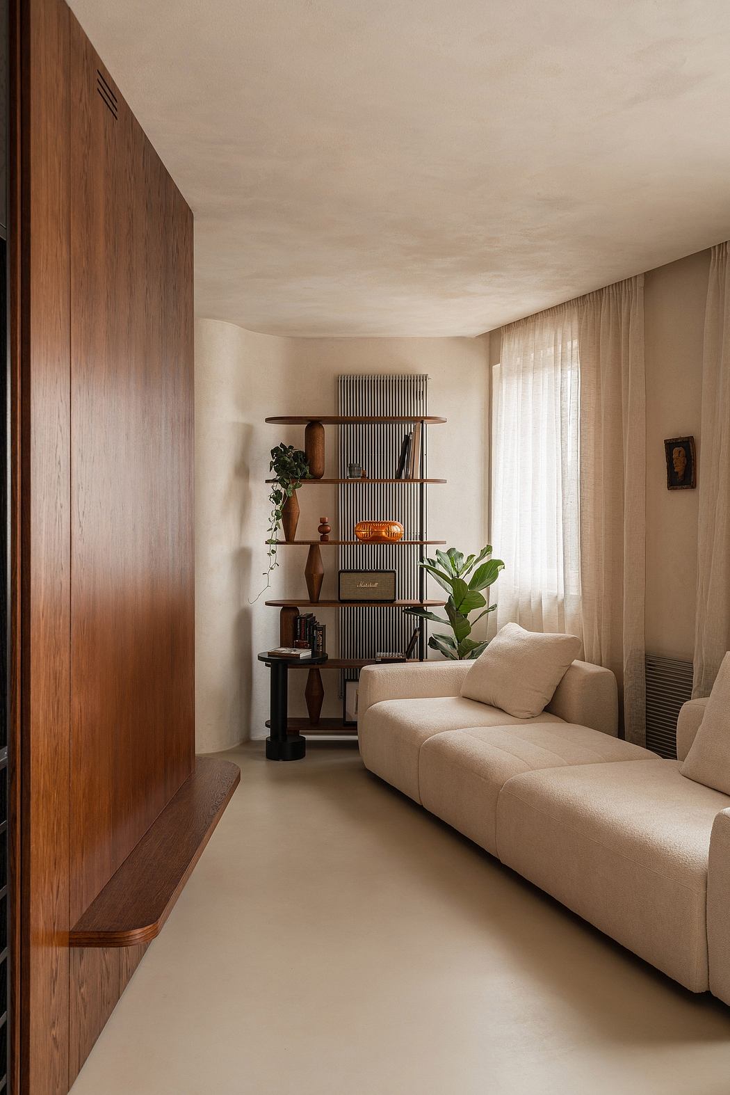 Warm, minimalist living room with wood paneling, built-in shelving, and neutral upholstery.