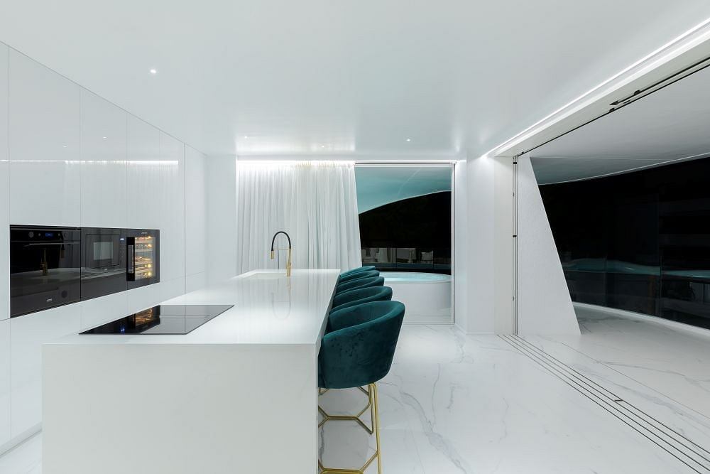 Sleek, modern kitchen with marble counters, minimalist design, and panoramic views.