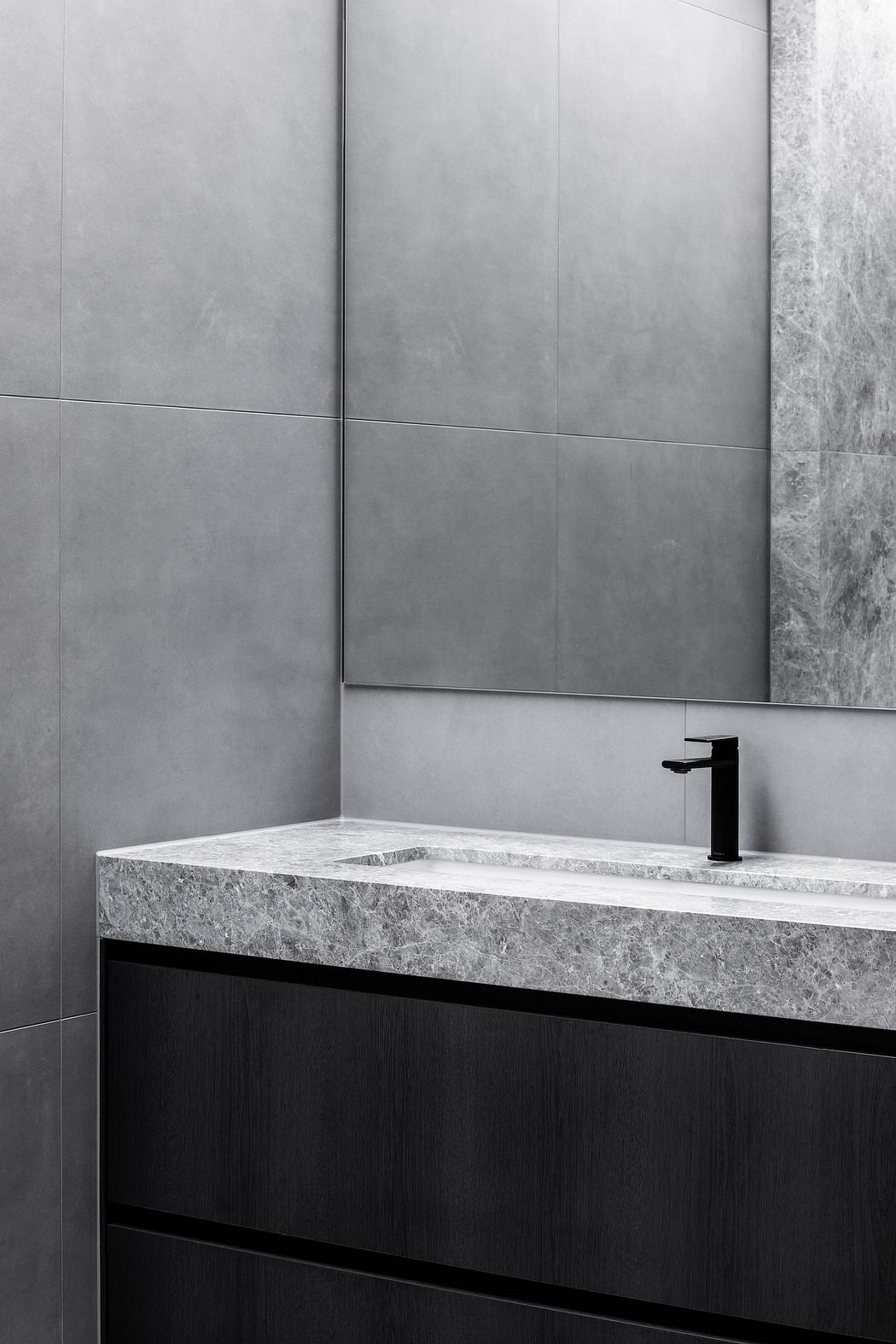 Contemporary vanity with stone countertop, dark wood drawers, and minimalist black faucet.