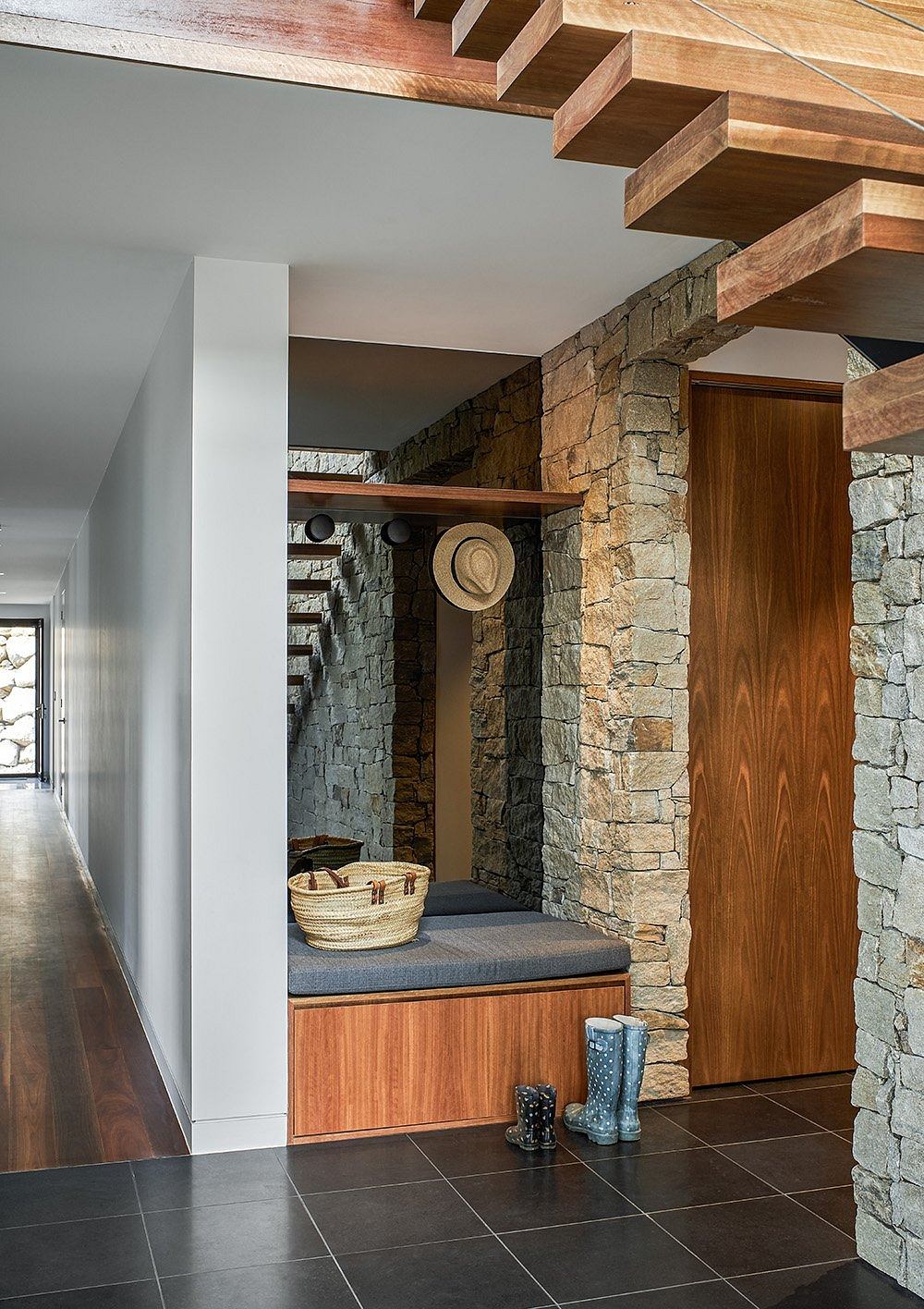 Rustic wood beams, stone walls, and built-in bench create a cozy, inviting entryway.