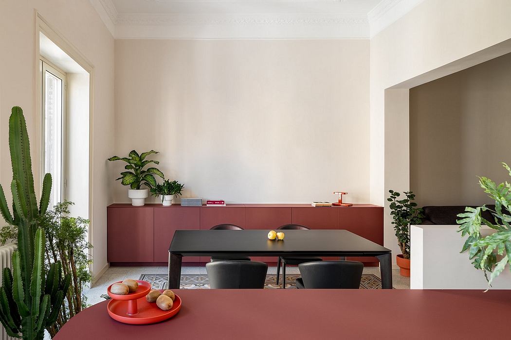 Minimalist dining room with maroon cabinetry, black table, and lush indoor plants.