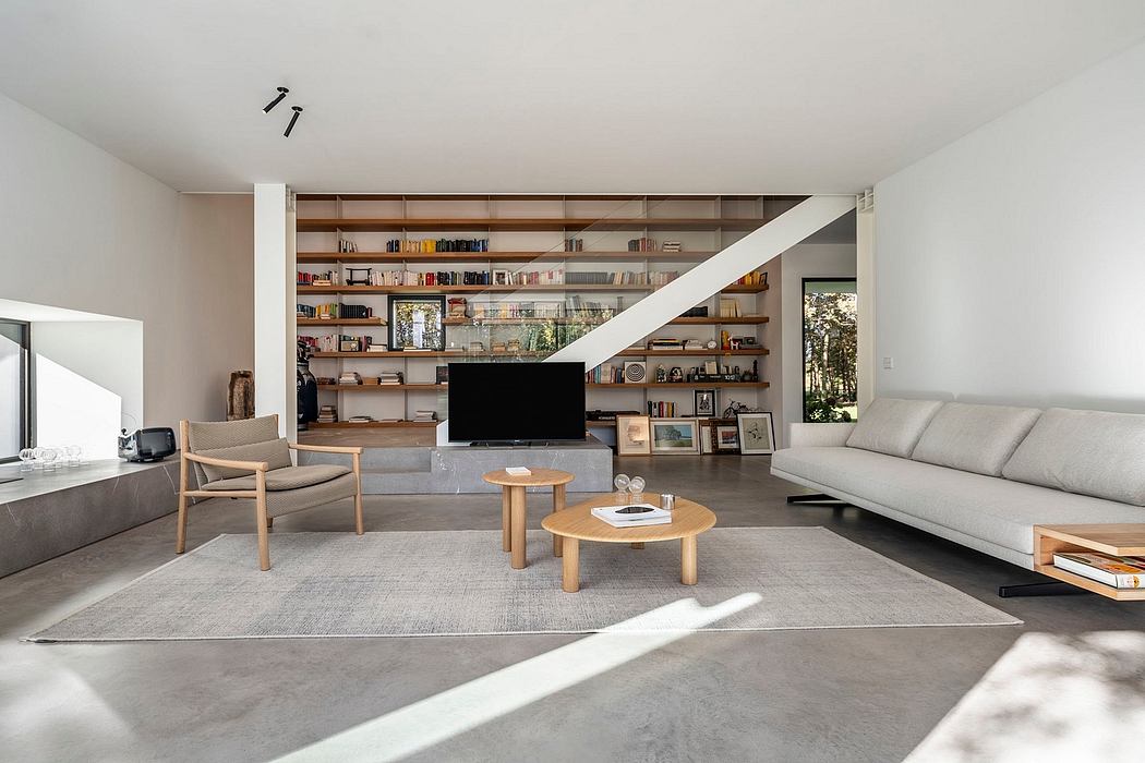 Modern, minimalist living room with open shelving, wood and concrete finishes.
