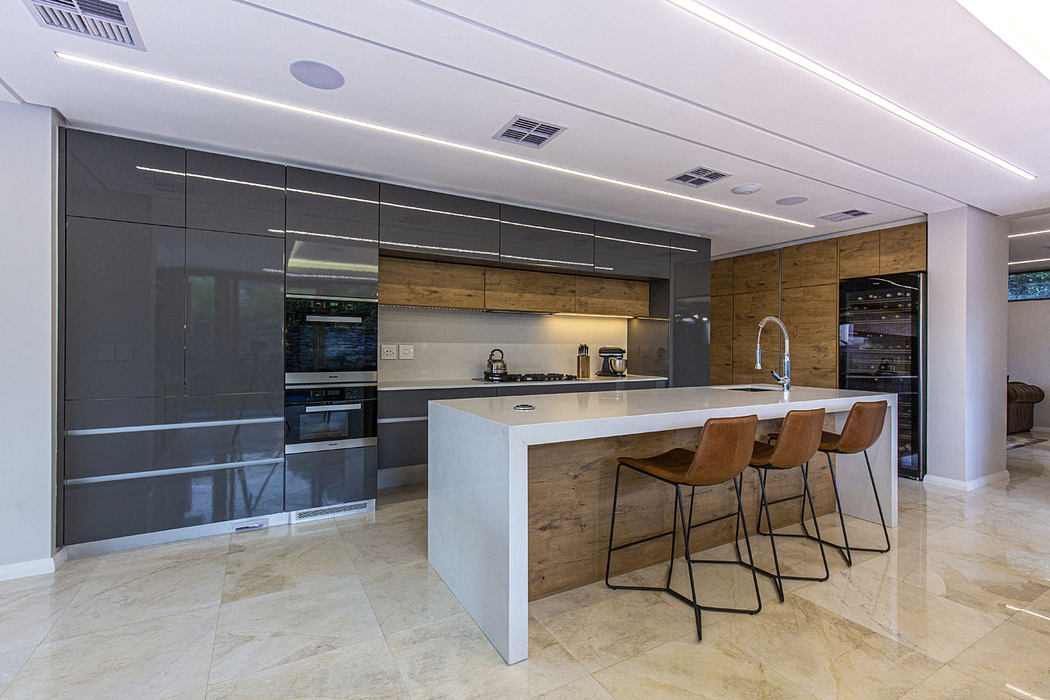 Sleek, contemporary kitchen with glossy cabinets, wooden accents, and a spacious island.