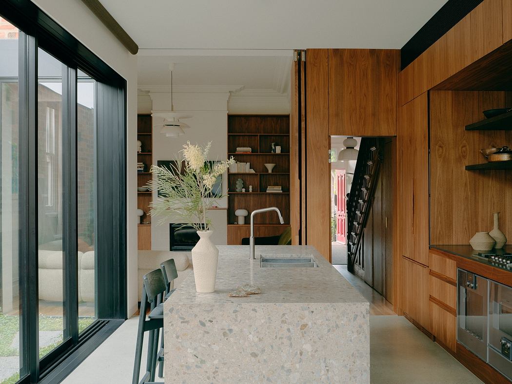 Minimalist kitchen design with a marble countertop, wooden cabinetry, and built-in shelves.