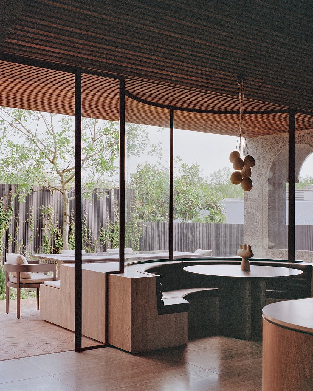 Sleek, modern interior with expansive glass walls, wooden details, and geometric furnishings.