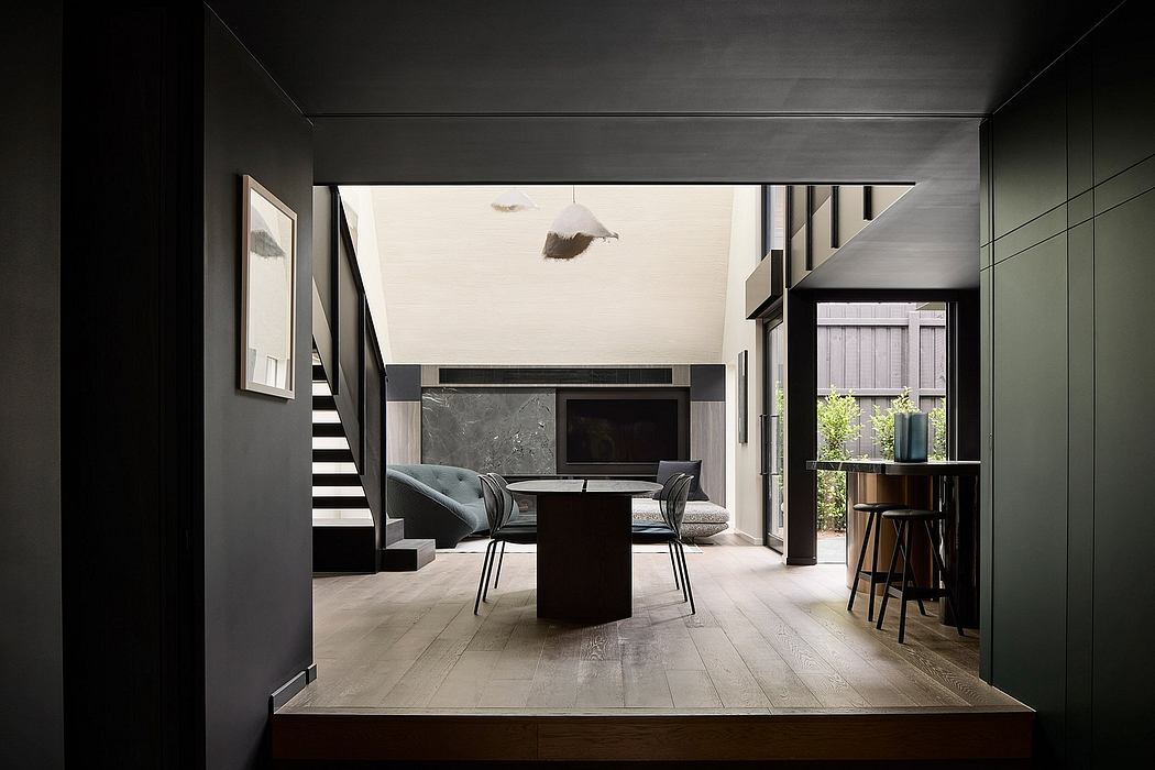 Striking black and white interior with sleek furniture, marble fireplace, and staircase.