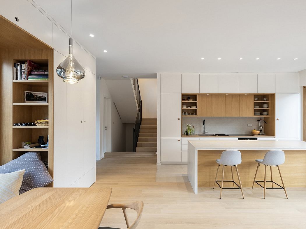 A modern, open-concept interior with wood finishes, built-in cabinetry, and a sleek kitchen island.