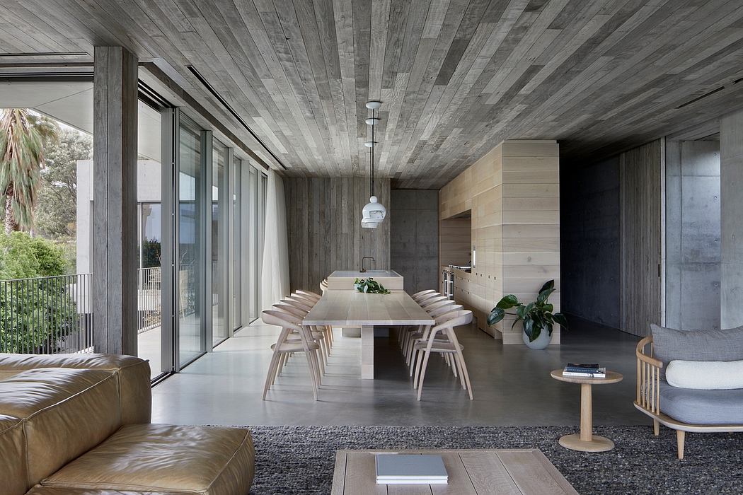Minimalist interior with exposed wooden beams, glass walls, and neutral furniture.