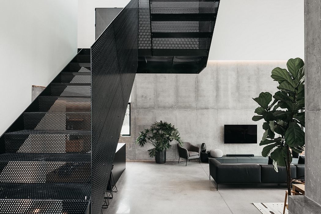 Striking geometric staircase leads to an airy, minimalist living space with lush greenery.