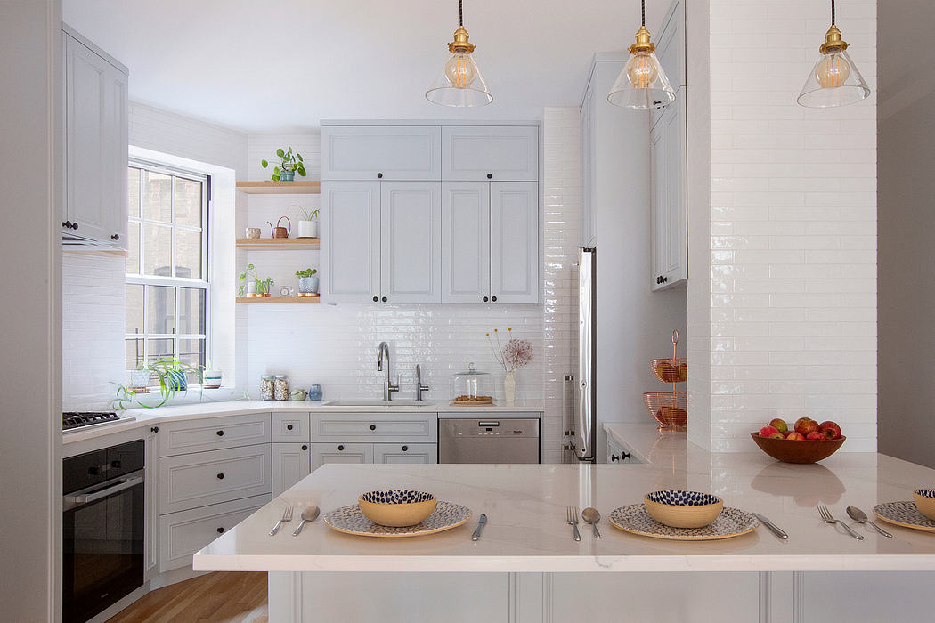 A bright, modern kitchen with white cabinets, open shelving, and patterned dishware.