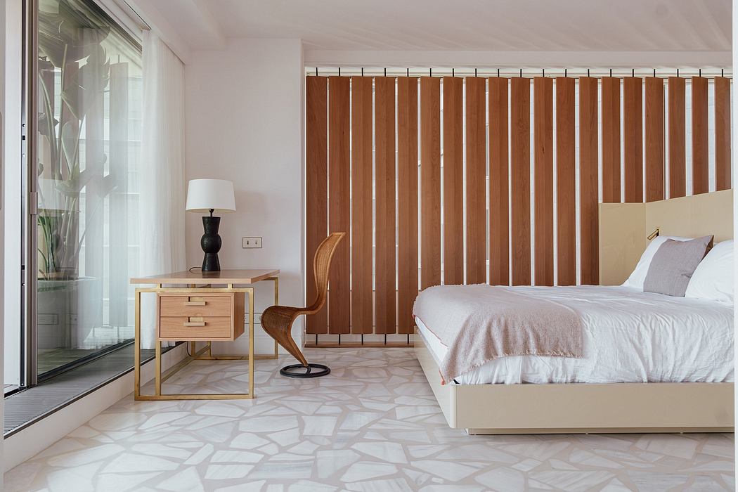 Minimalist bedroom with wooden slat wall, stone tile flooring, and contemporary furniture.