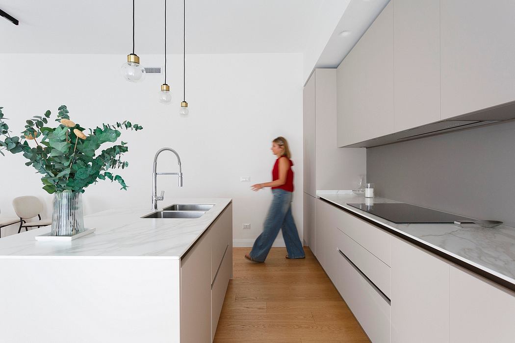 Modern, minimalist kitchen with sleek cabinetry, pendant lighting, and a central island.