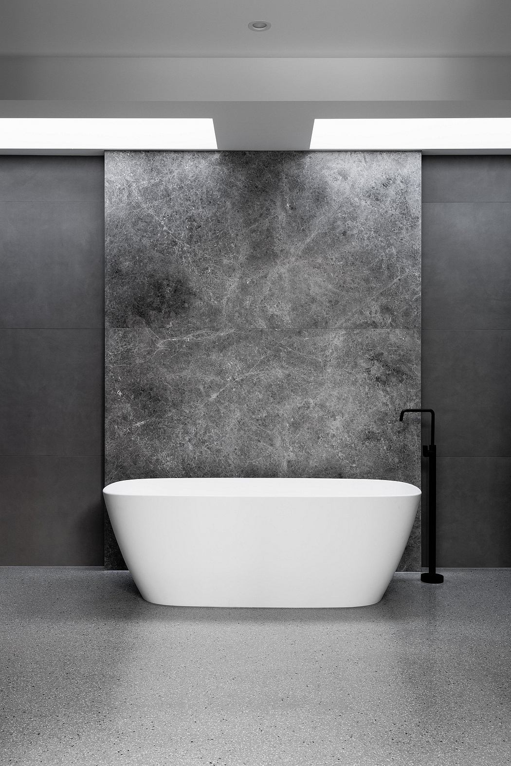 Minimalist bathroom design with freestanding white tub, dark stone walls, and black faucet.