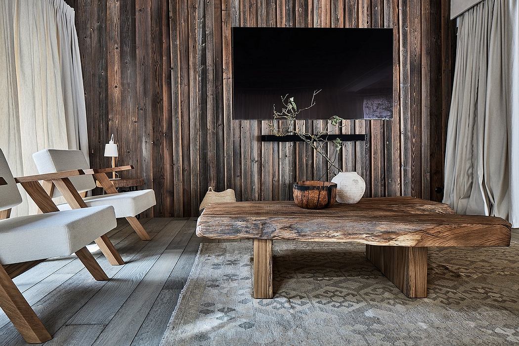 The rustic wooden cabin features a large flat-screen TV mounted on the wall and a minimalist coffee table made of natural wood.