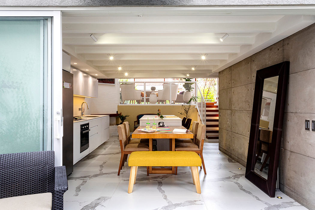 Sleek, modern kitchen and dining area with concrete walls, wood furnishings, and natural lighting.