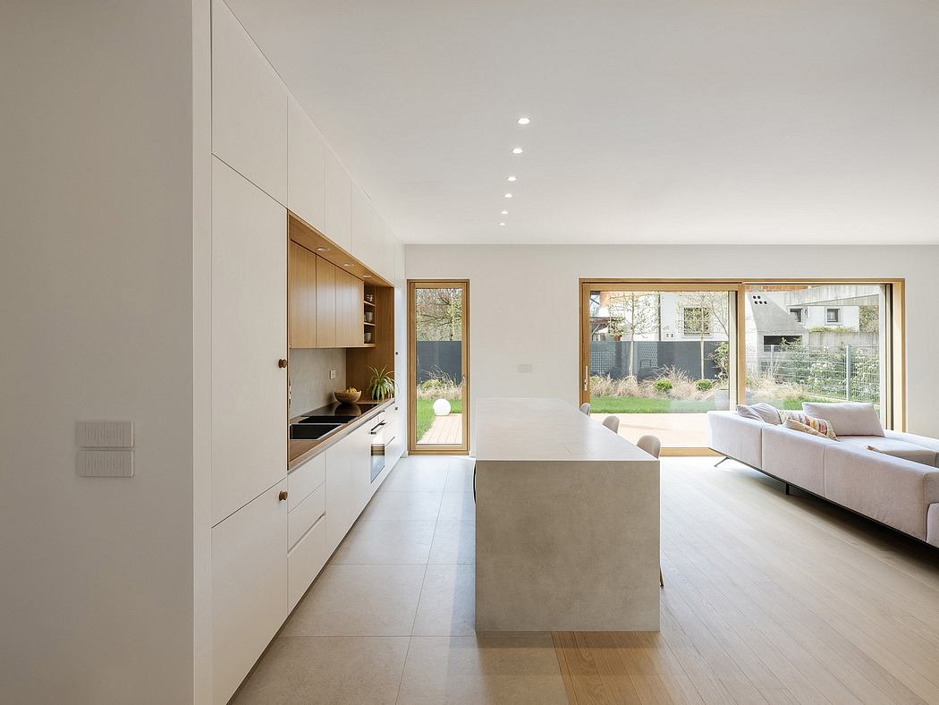 Sleek, minimalist kitchen with wooden cabinetry and large windows overlooking a garden.