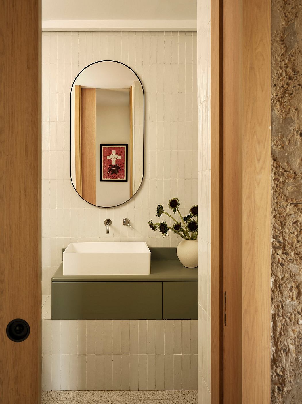 Sleek, minimalist bathroom with arched mirror, floating vanity, and natural accents.
