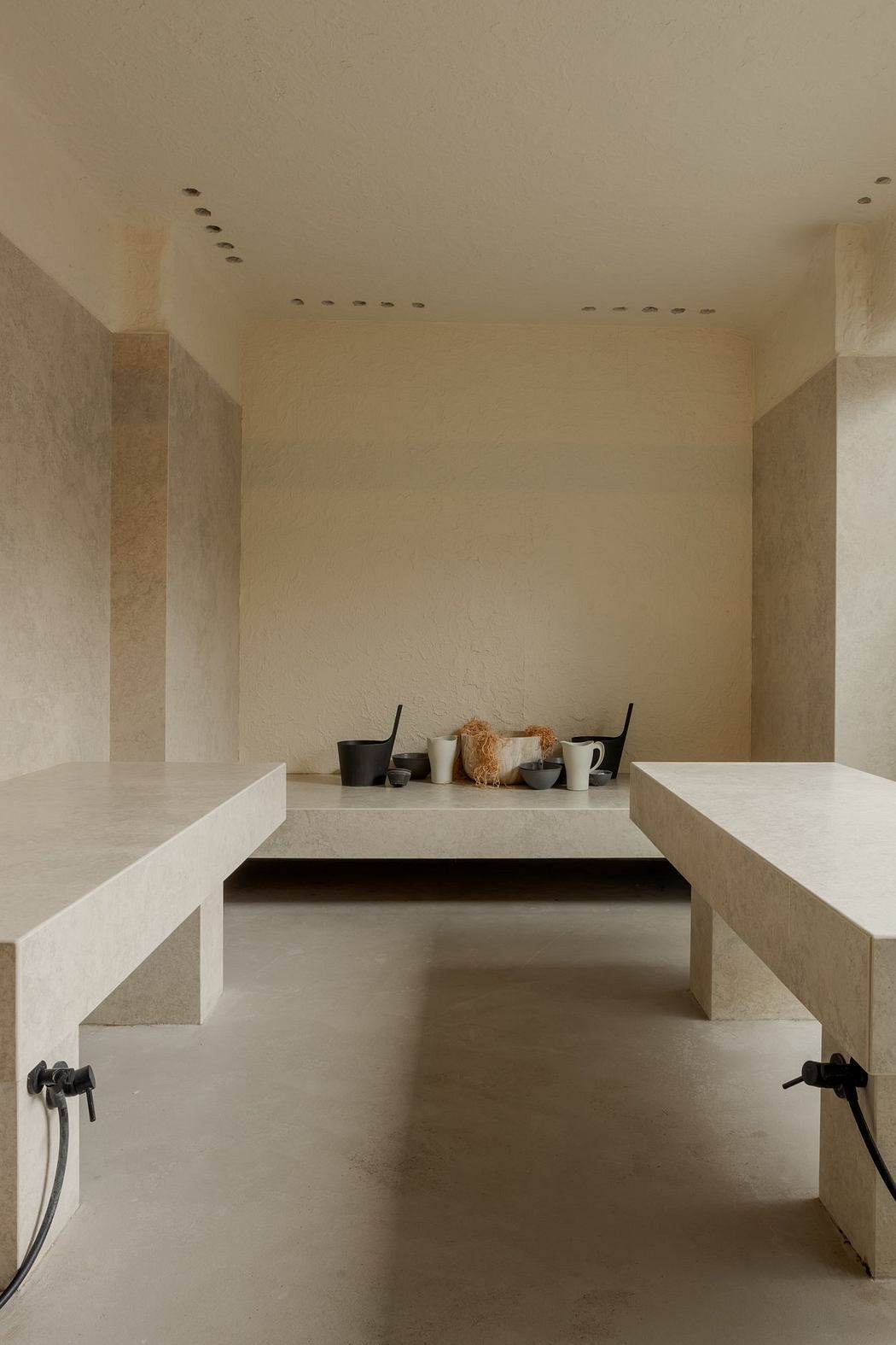 Minimalist interior with recessed lighting, built-in shelves, and a central wooden table.