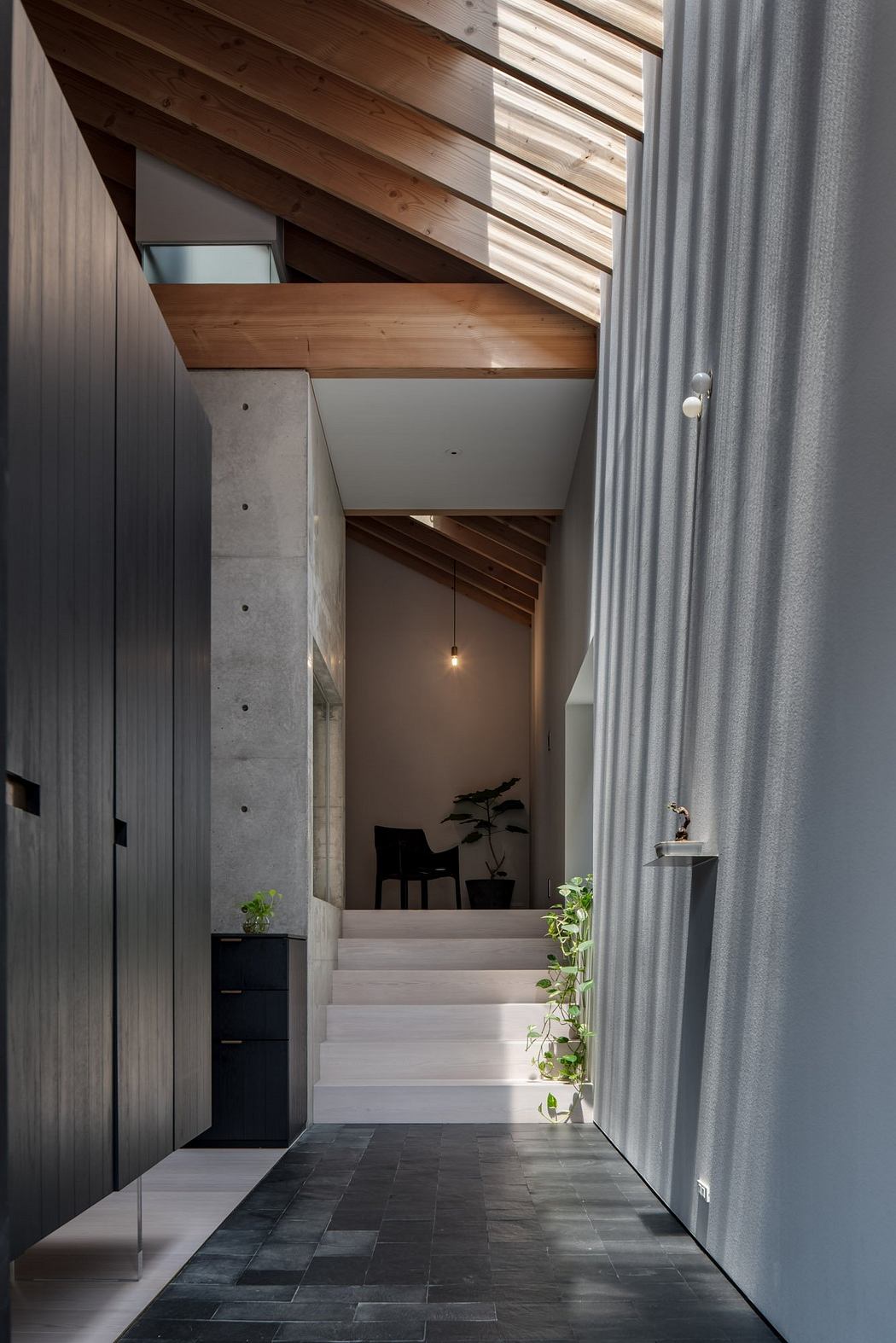 Wooden beams, concrete walls, and a minimalist staircase lead to a cozy, warm space.