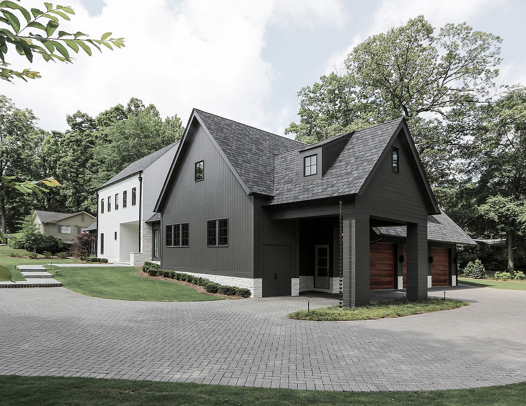A contemporary farmhouse-style home with a gabled roof, wood accents, and a paved driveway.