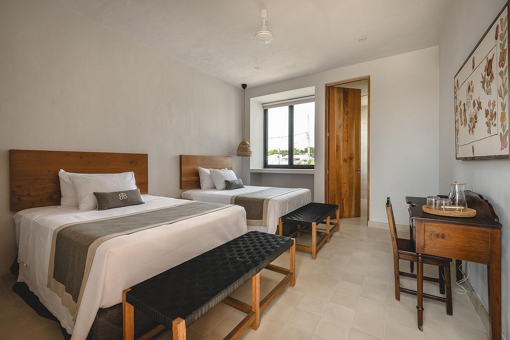 Spacious guest room with wooden furniture, tile flooring, and a wall-mounted artwork.