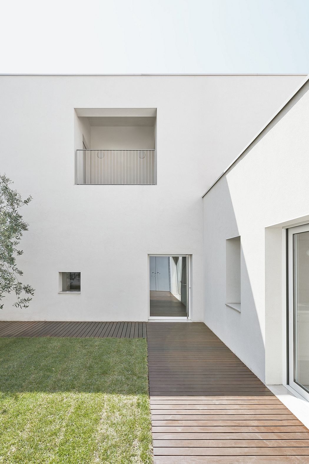 Minimalist exterior with clean lines, wooden deck, and recessed window details.