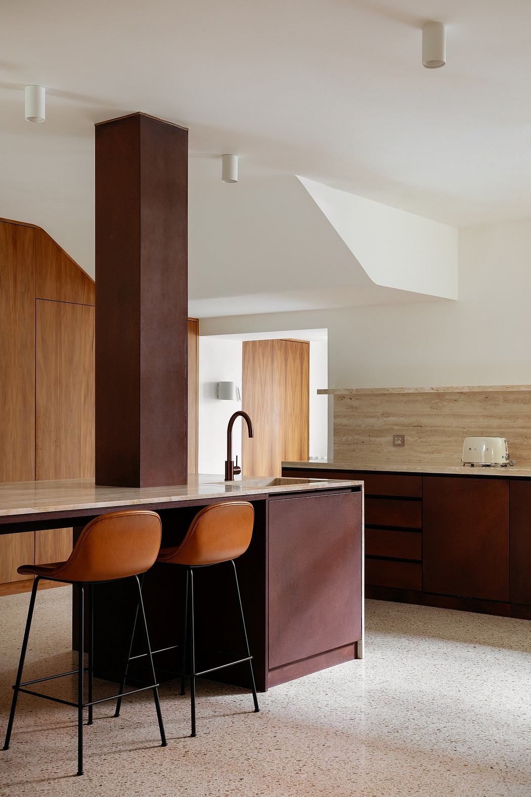 Minimalist kitchen with warm wood tones, sleek cabinets, and modern bar stools.