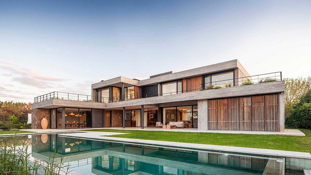 Modern, multi-story residential home with clean lines, large windows, and a pool in the foreground.