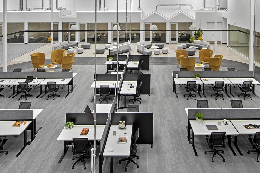 Expansive modern office space with modular workstations, lounge areas, and sleek lighting.