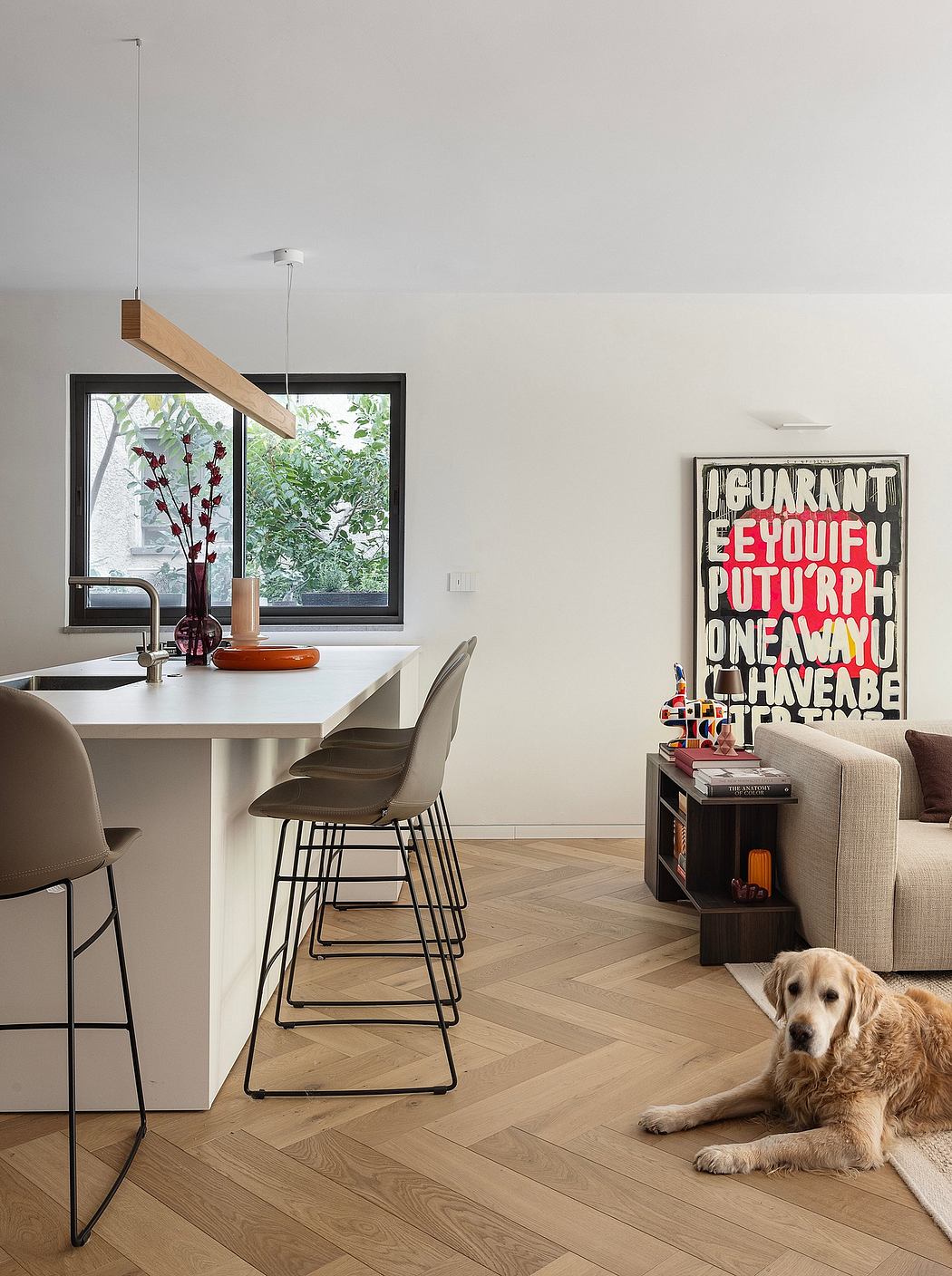 Sleek, modern kitchen with wood-paneled accents, vibrant artwork, and a relaxed canine companion.