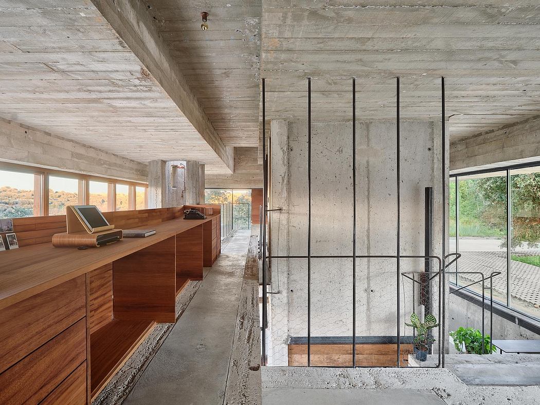 Minimalist concrete and wood interior with built-in storage and large windows.