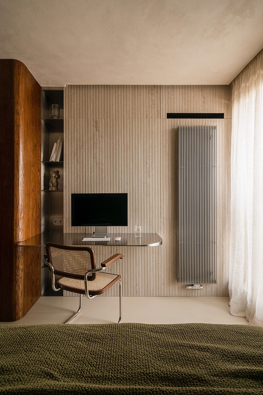 Minimalist, textured living space with vertical wood paneling, shelving, and a cozy armchair.