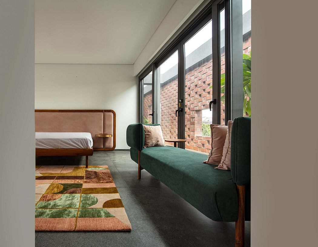 Cozy bedroom with large windows, wood furniture, and vibrant patterned carpet.