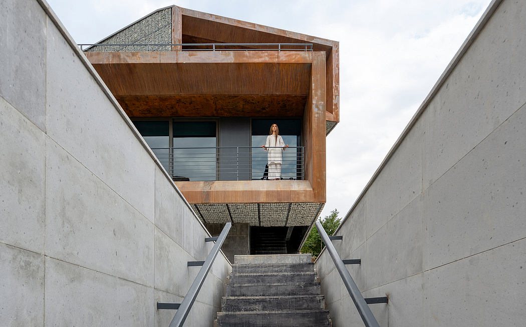 Concrete and wooden structure with balcony overlooking stairs, showcasing modern architectural design.