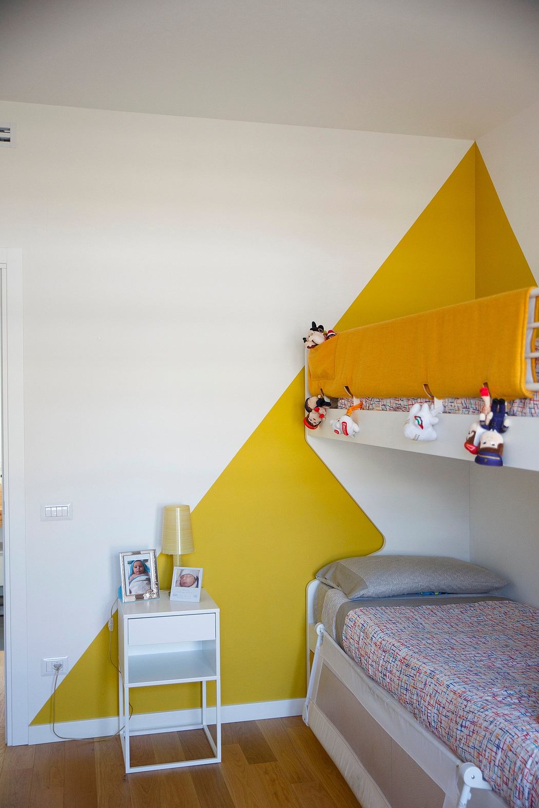 Bright, geometric yellow wall accent contrasts white interior, highlighting modern decor.