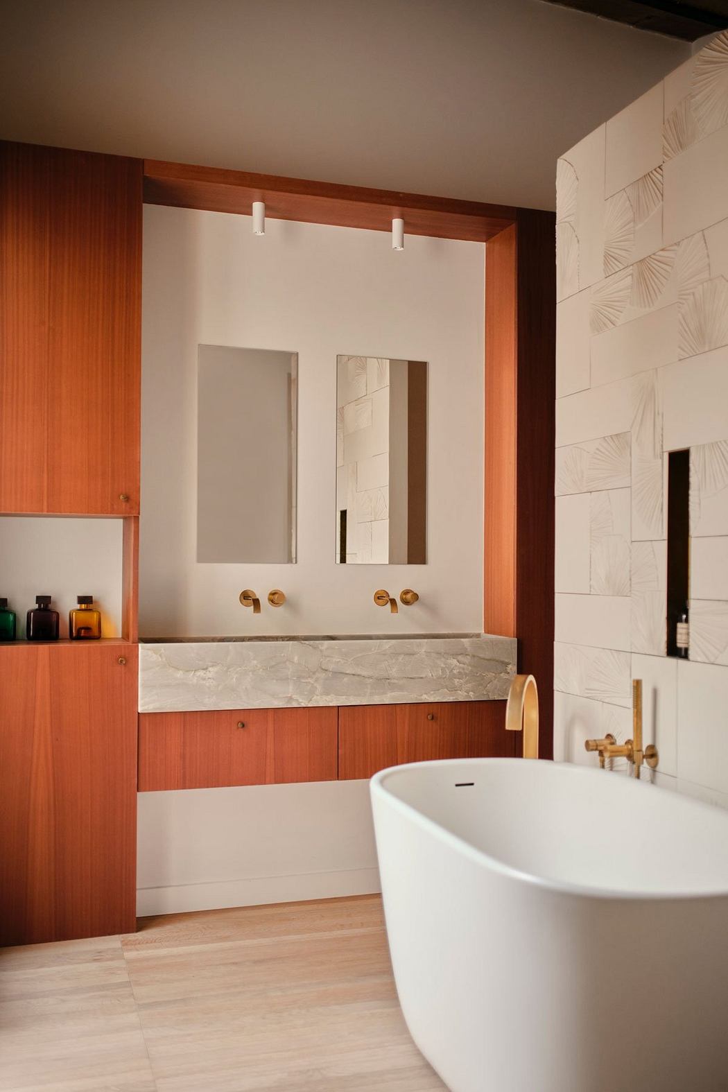 Modern bathroom with wooden accents, marble vanity, and freestanding bathtub.