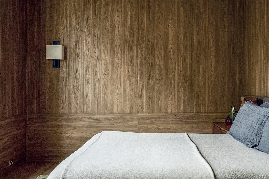 Warm-toned wood paneling, minimalist décor, and a cozy bedroom setup.