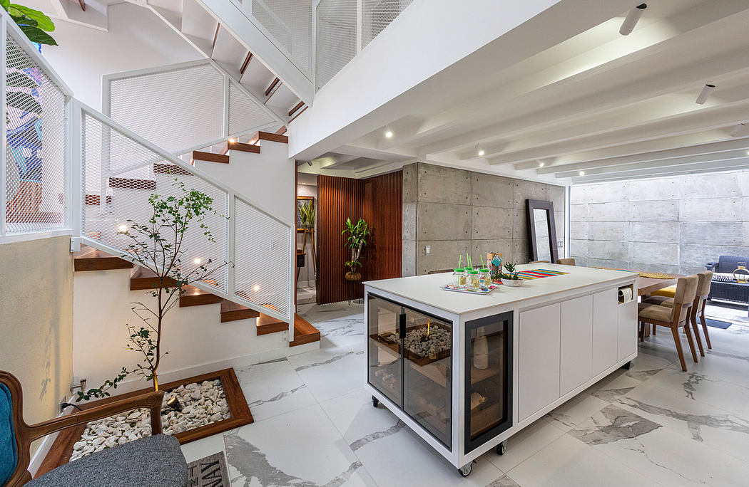 Spacious open-plan design with concrete walls, wooden stairs, and a modern kitchen island.