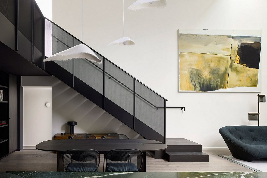 A modern interior with a black metal staircase, an abstract painting, and a dining table.