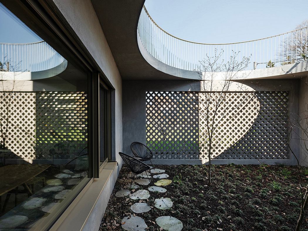 A modern, curved building exterior with latticed screens and a secluded garden courtyard.