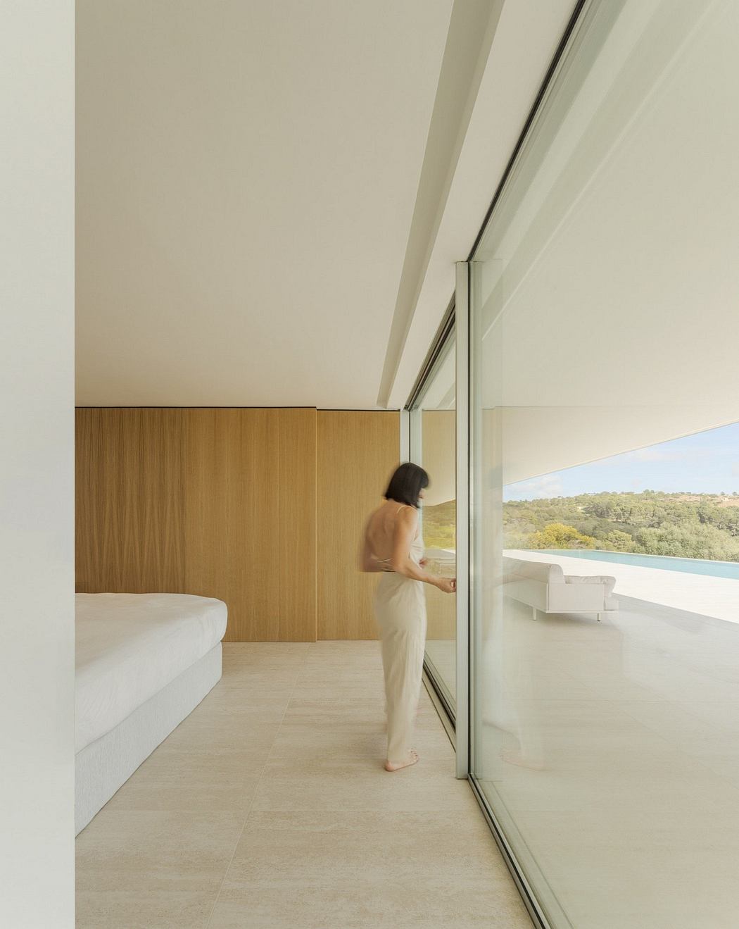 Interior with panoramic glass windows overlooking natural scenery. Minimalist, warm-toned design.
