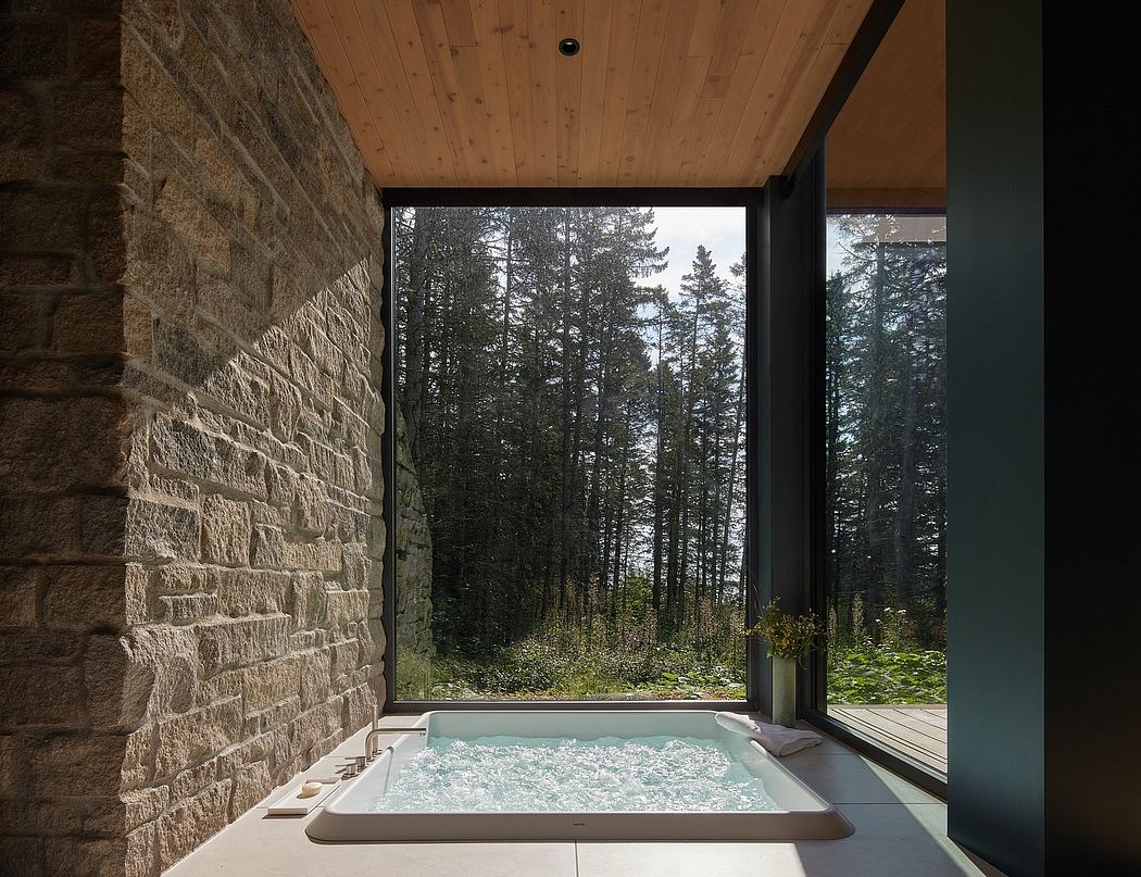 Rustic wooden cabin interior with floor-to-ceiling windows overlooking a forested landscape.