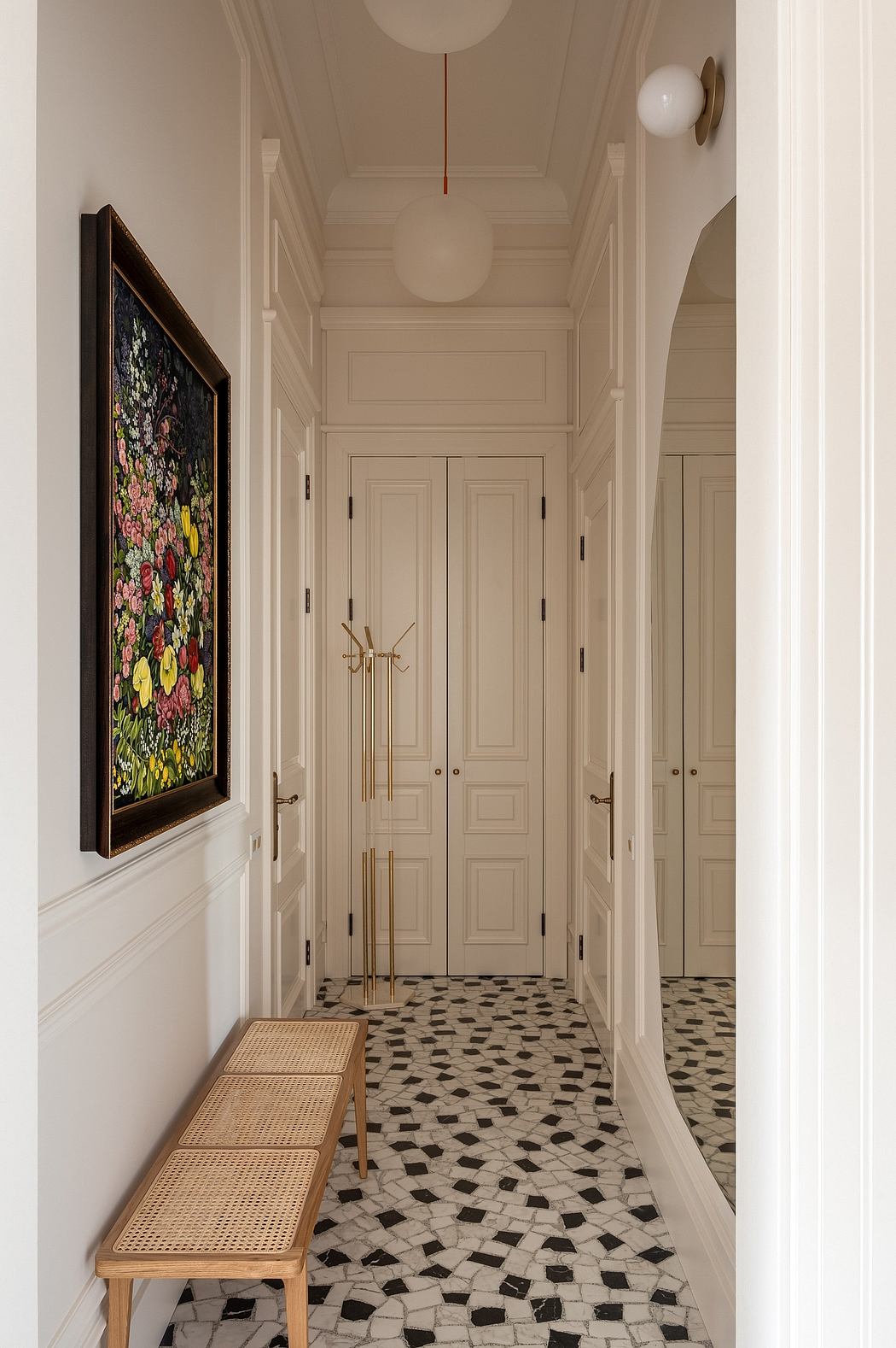 Ornate hallway with intricate tile flooring, white paneled walls, and decorative artwork.