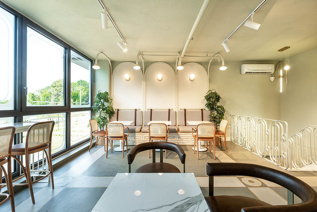 Stylish interior with arched lighting, wood furniture, and large windows overlooking greenery.