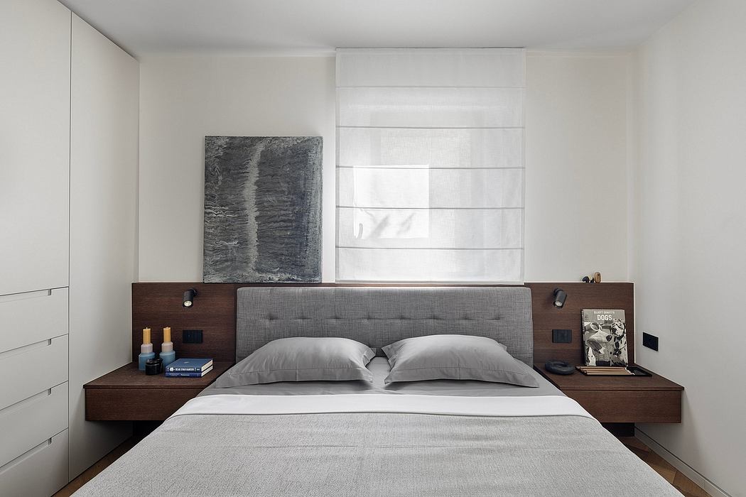 A minimalist bedroom featuring a modern, wood-paneled headboard and bedside tables.