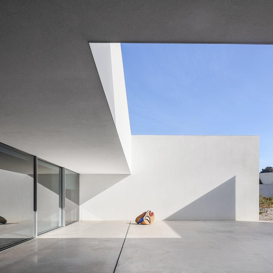 A minimalist architectural space with large windows, a white ceiling, and a concrete floor.