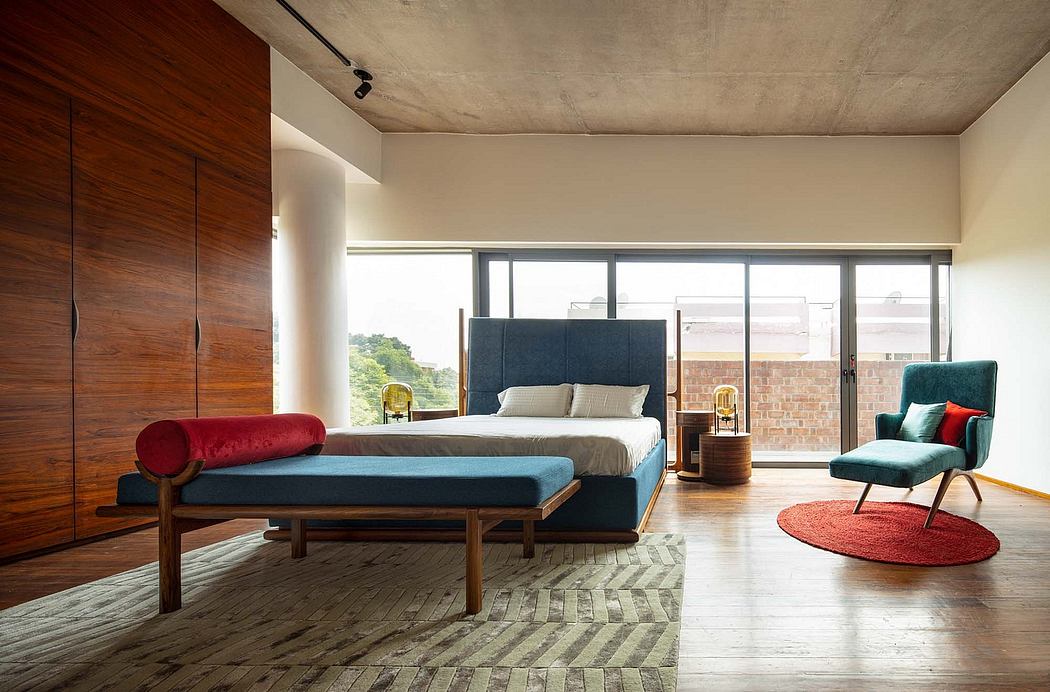 Spacious modern bedroom with concrete ceiling, wooden closet, and vibrant furnishings.