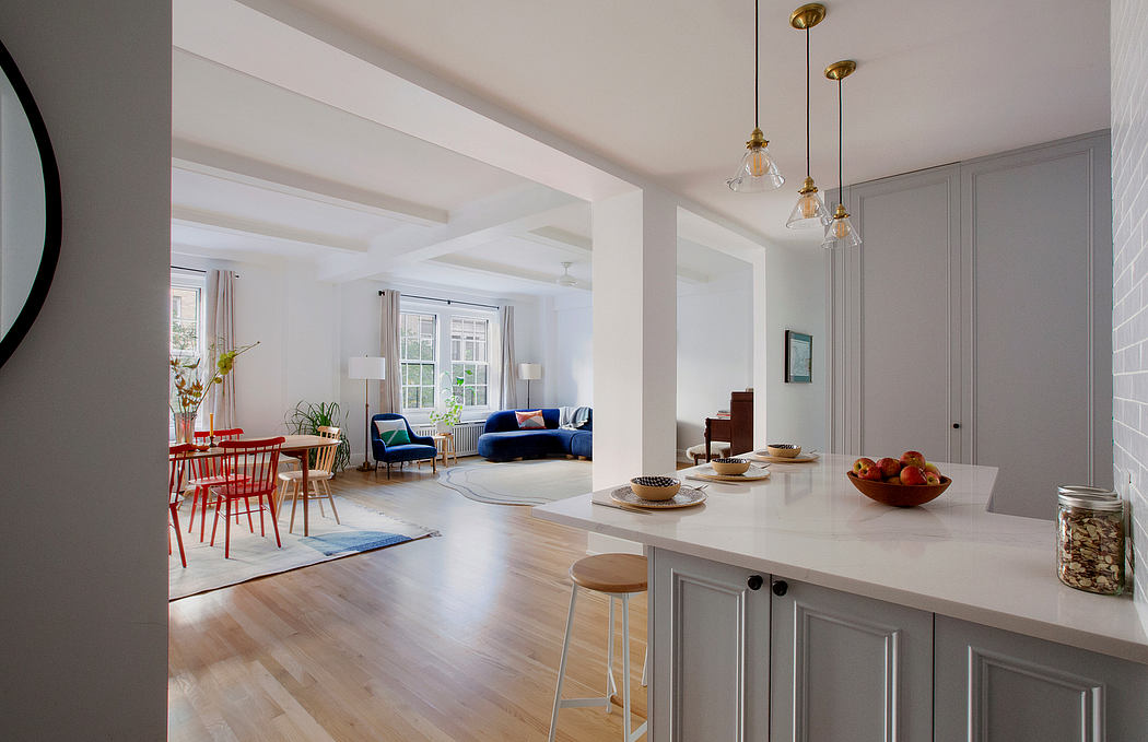 Bright, open-concept living space with modern furnishings, wood floors, and pendant lights.