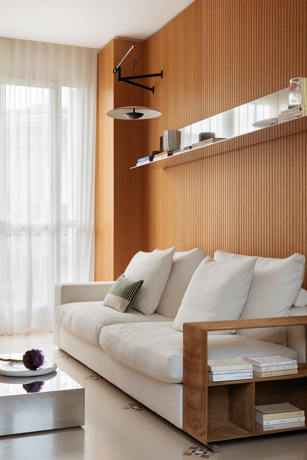 Cozy living room with wooden slat wall, plush white sofa, and minimalist decor.